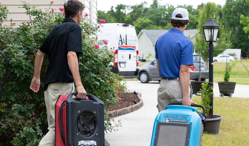 Mold remediation professionals using air drying equipment at a residential property