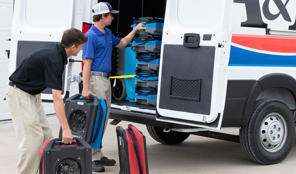 Charleston water damage restoration professionals loading drying equipment into a service van